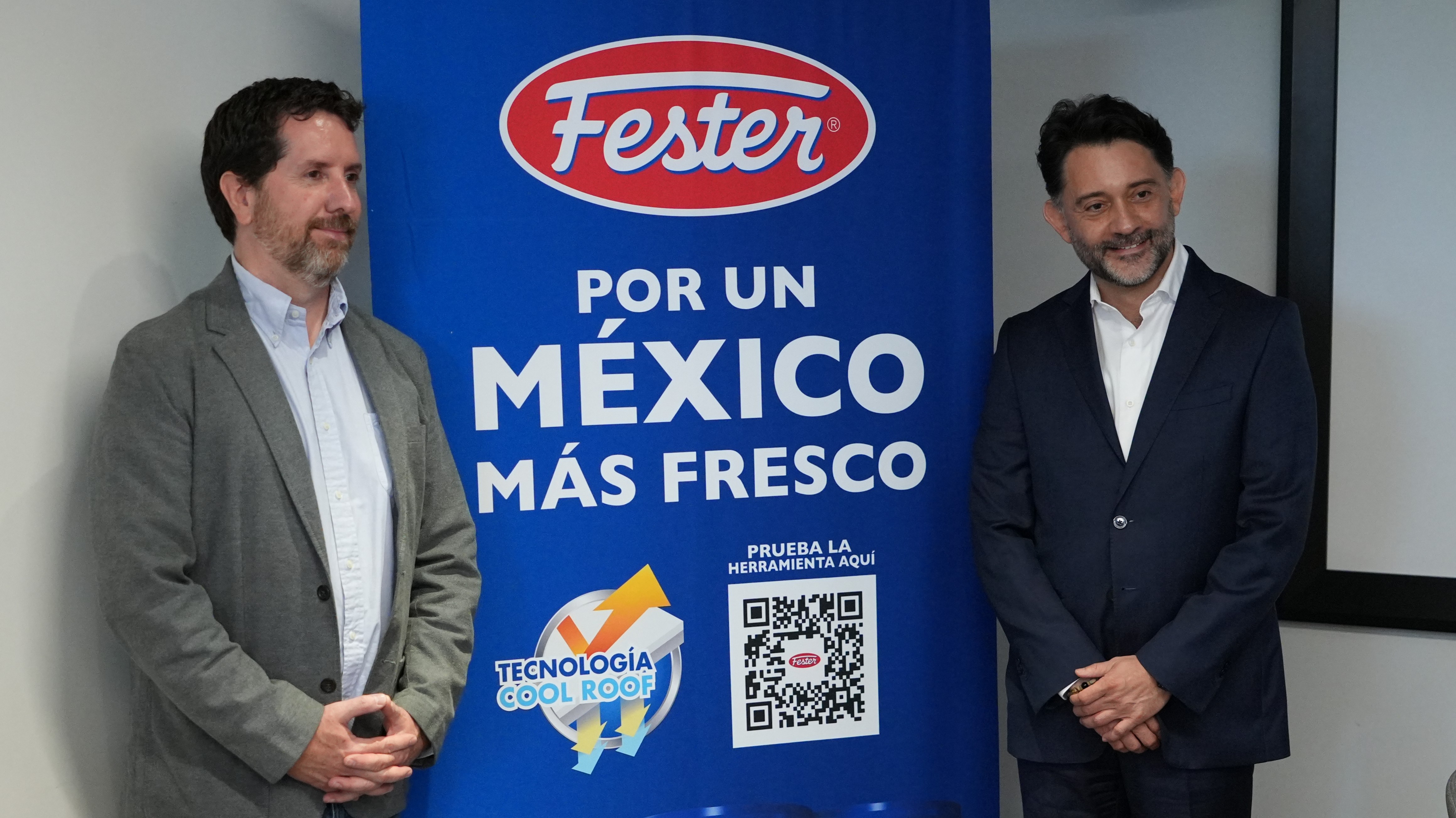 Dos personas de pie junto a un banner vertical azul de la marca Fester. El banner muestra el logotipo “Fester” y el texto “Por un México más fresco”, seguido de un código QR y el sello “Tecnología Cool Roof”.