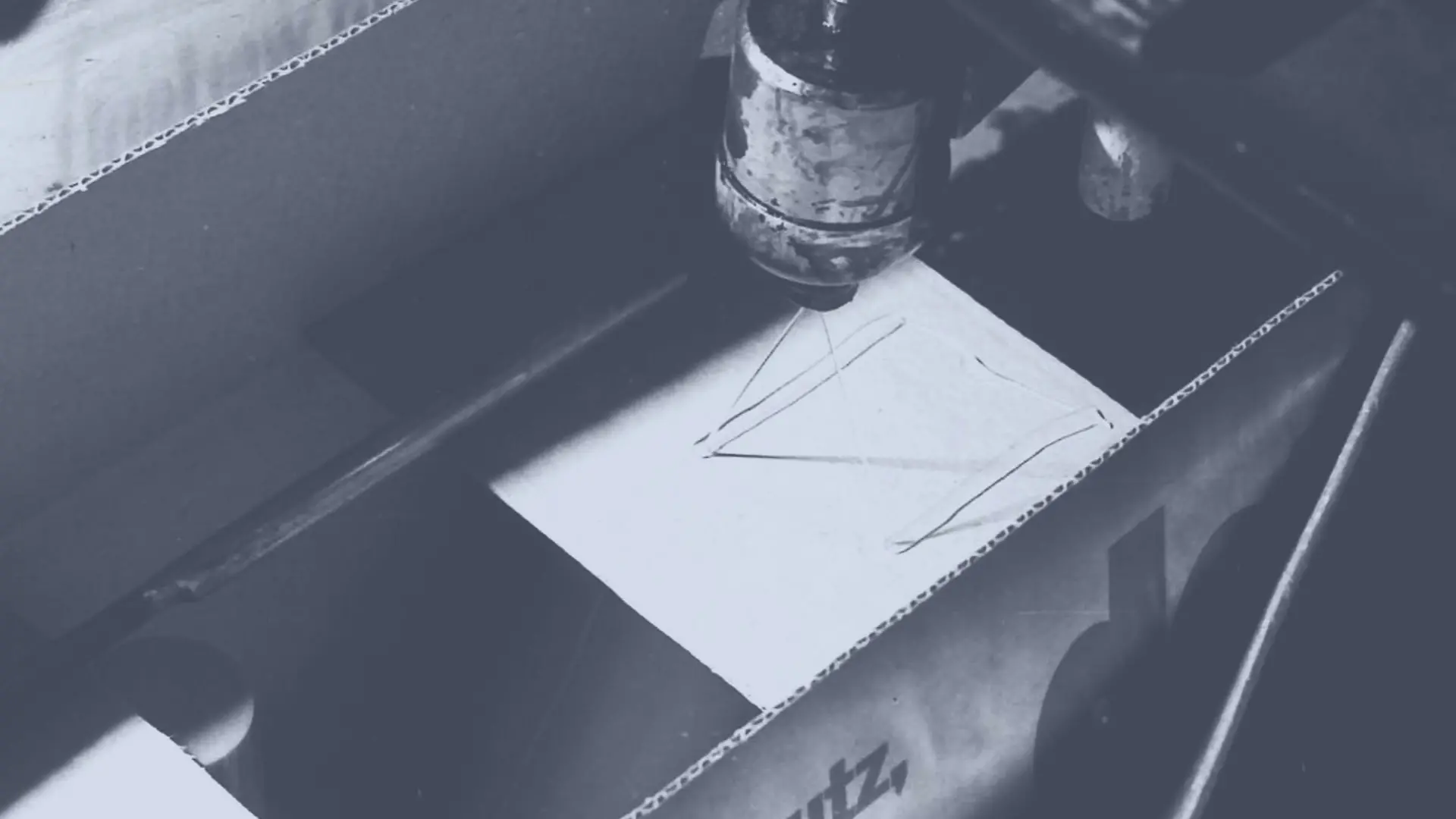 Aplicación del adhesivo termofusible Technomelt a una caja de cartón mediante una boquilla pulverizadora para sellarla.