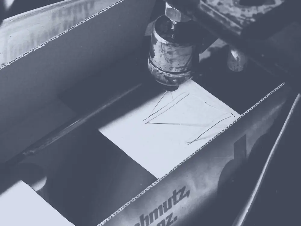 Aplicación del adhesivo termofusible Technomelt a una caja de cartón mediante una boquilla pulverizadora para sellarla.